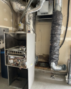 An HVAC furnace with its cover removed, showing internal components during a repair service by AC Heating & Cooling in Meridian, ID.