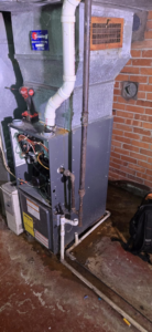 An HVAC furnace with its panel open, showing internal components during a service call by McBride HVAC Solutions LLC in Cincinnati, OH