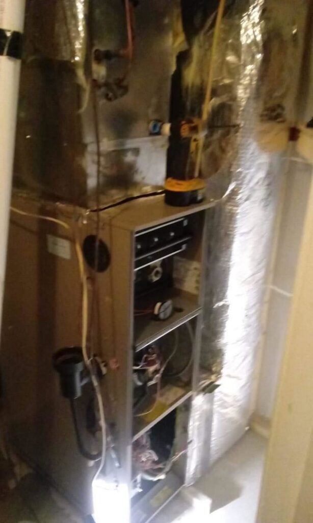 An HVAC furnace undergoing repair or service, with internal components visible, by ReDesign Air in Winchester, VA.