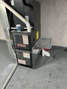 A Goodman furnace unit with a dirty air filter next to it, indicating HVAC service by AG Plumbing in Pittsburgh, PA.