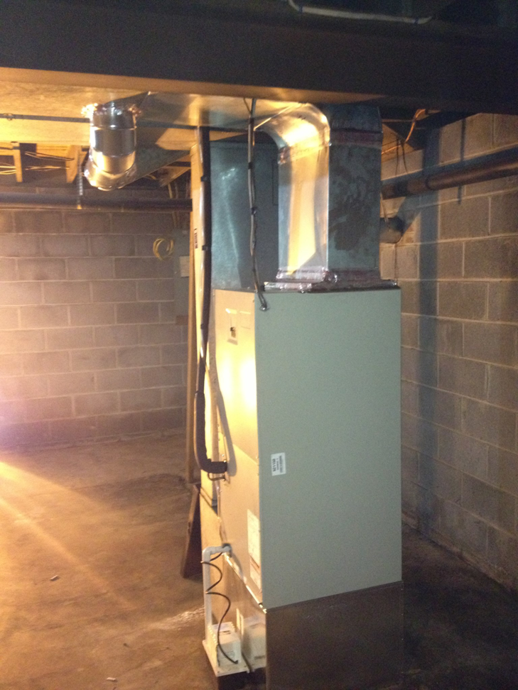 An HVAC furnace system with connected ductwork in a residential basement, installed by L & R Electrical and HVAC Services in San Marcos, CA.