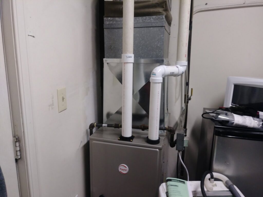 An HVAC furnace system with ductwork and PVC pipes installed by Bean'z Heating and Cooling in Chicago, IL.
