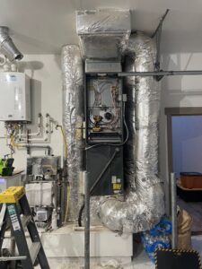 An HVAC furnace system with ductwork and a tankless water heater installed by AC Heating & Cooling in Meridian, ID.