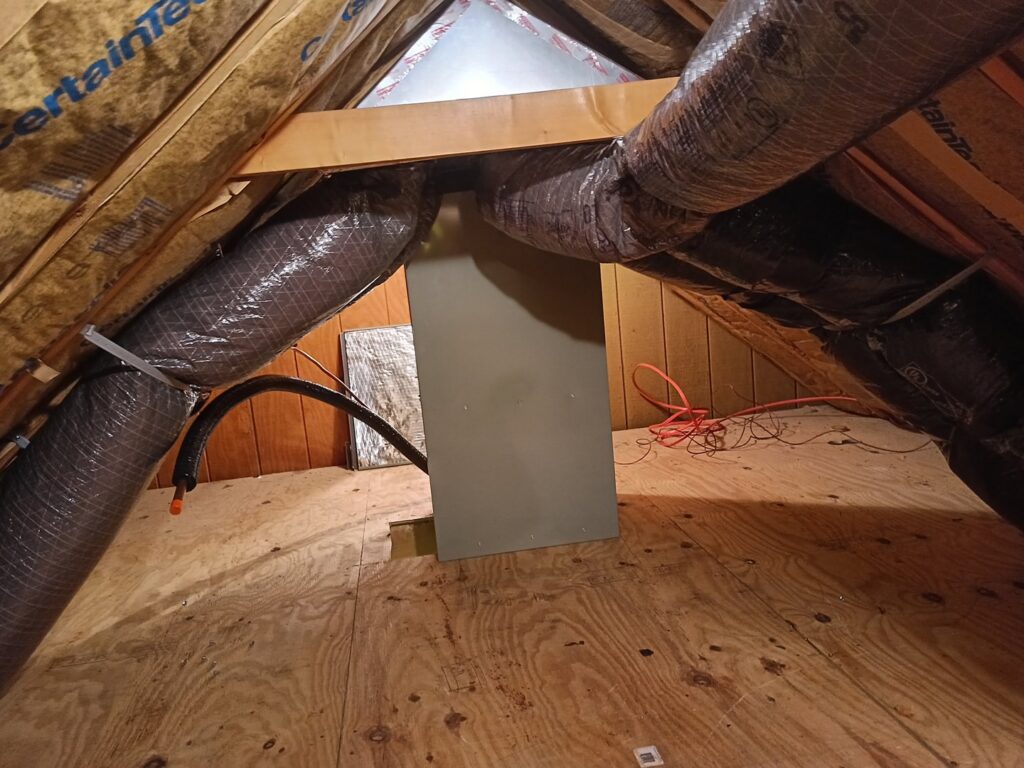 An HVAC furnace unit and insulated ductwork installed in an attic, showing work by TAS Mechanical Services in Kearney, MO.