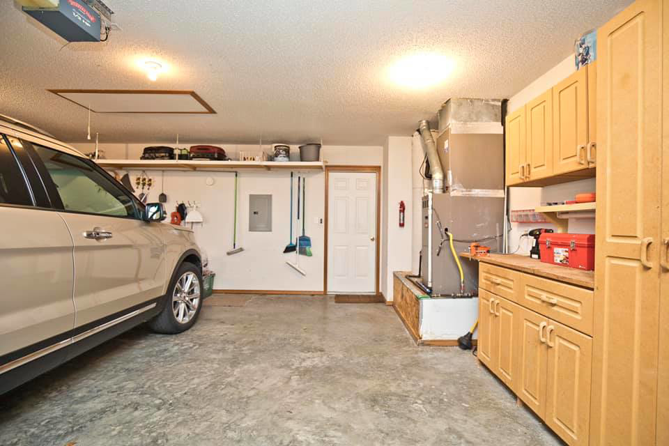 An HVAC furnace unit and ductwork visible in a garage, representing services by Pam Spies in Bentonville, AR