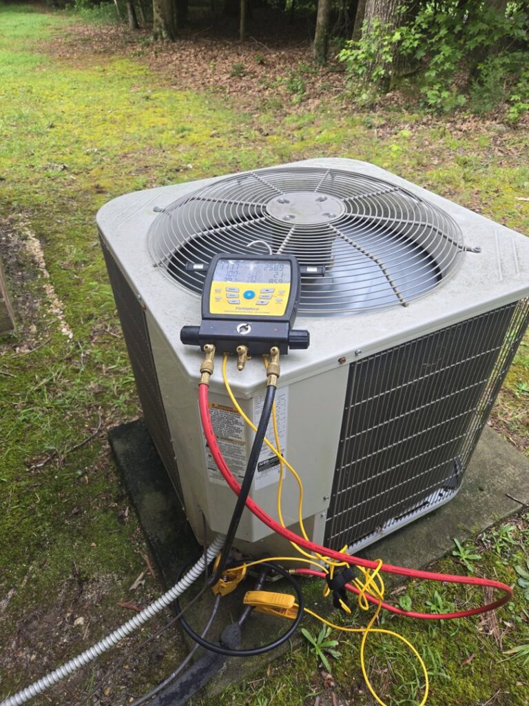 HVAC gauges connected to an outdoor air conditioning unit during service by Booker Heating & Air in Richmond, VA.