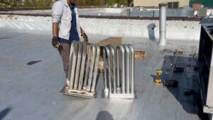 A technician replacing a heat exchanger on a rooftop for Modern HVAC Technology in Chicago, IL.