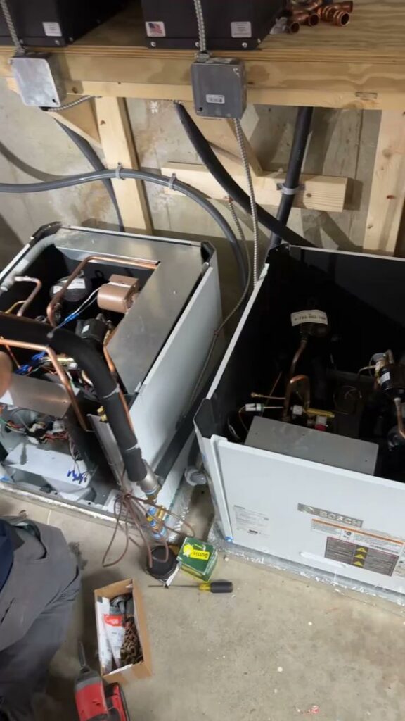 Technicians working on indoor HVAC units during installation or service by Ultra Installs in Barrington, NH