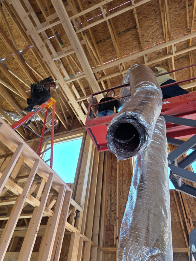 An HVAC installation crew working on flexible ductwork in a new building for Lone Star Mechanical in El Paso, TX.