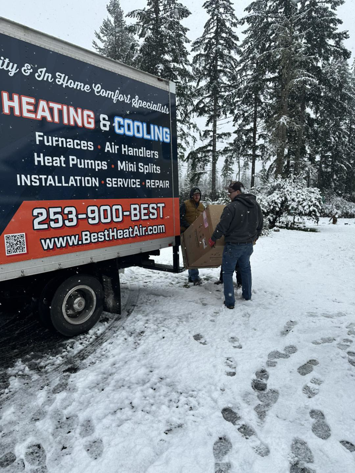 Two technicians from Best Heat & Air delivering a new HVAC unit for installation in Tacoma, WA.