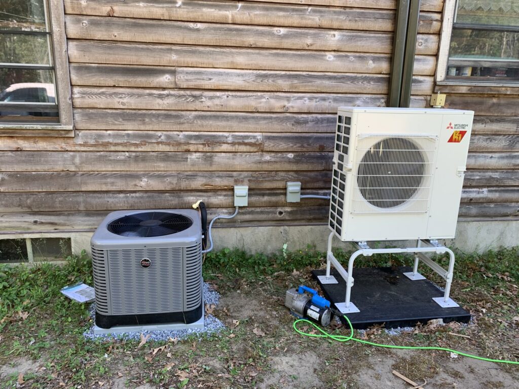 An outdoor heat pump and AC unit being installed by Superior CO-OP HVAC in Cambridge, NY, with a vacuum pump visible.