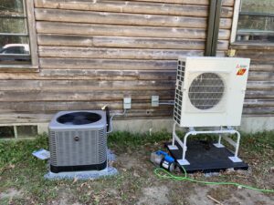 An outdoor heat pump and AC unit being installed by Superior CO-OP HVAC in Cambridge, NY, with a vacuum pump visible.