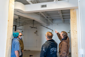 HVAC professionals inspecting new ductwork and vents during a commercial installation by Comfort Engineering Co Inc in Tupelo, MS