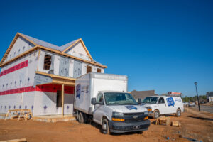 Bob Woodall Air Care Systems vehicles parked at a new construction site for HVAC installation in Dothan, AL.