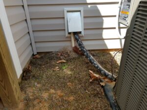 Close-up of HVAC lineset and electrical conduit professionally installed into a house by NAS Heating & Air in Fayetteville, NC.