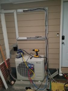 HVAC technicians performing a mini-split installation with tools and gauges at a home in Roanoke, VA by A.C. Installing.