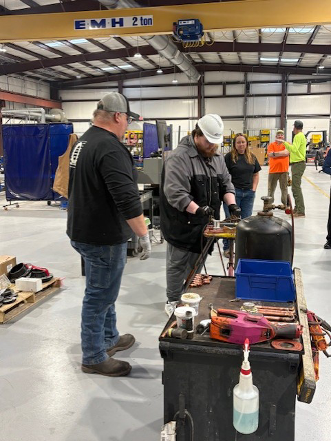 HVAC technicians working on pipefitting and welding in a training facility at QuesTec in Columbia, MO