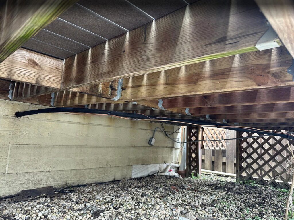 HVAC or plumbing lines installed neatly under a residential deck by Deljo Heating, Cooling & Plumbing in Chicago, IL.