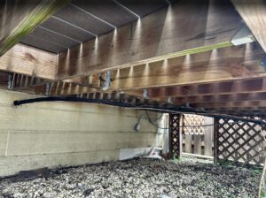 HVAC or plumbing lines installed neatly under a residential deck by Deljo Heating, Cooling & Plumbing in Chicago, IL.