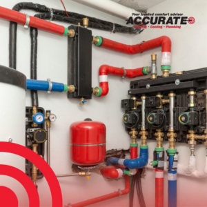 A detailed view of a complex HVAC and plumbing system installation with red and blue pipes by Accurate Mechanical in Columbus, OH