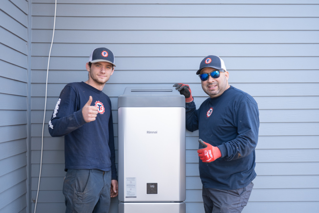 Two technicians from Travis Crawford Heating, Cooling, Plumbing & Electrical installing a Rinnai water heater in Charlotte, NC.