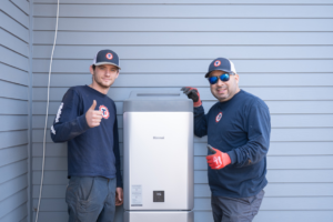 Two technicians from Travis Crawford Heating, Cooling, Plumbing & Electrical installing a Rinnai water heater in Charlotte, NC.