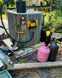 An outdoor HVAC condenser unit being serviced with refrigerant gauges and a Freon R410A tank by Ortez Home Services LLC in Charlotte, NC.