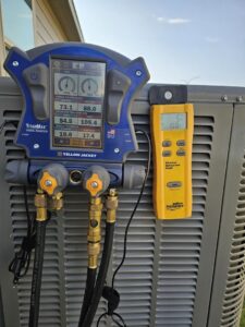 Digital manifold gauge and wireless refrigerant scale connected to an outdoor AC unit for service by MasterCraft Mechanical, LLC. in Haslet, TX.