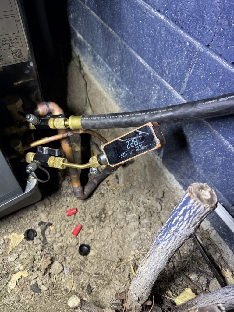A digital refrigerant gauge connected to an HVAC unit for diagnostics by LeoAir, LLC in West Jordan, UT.