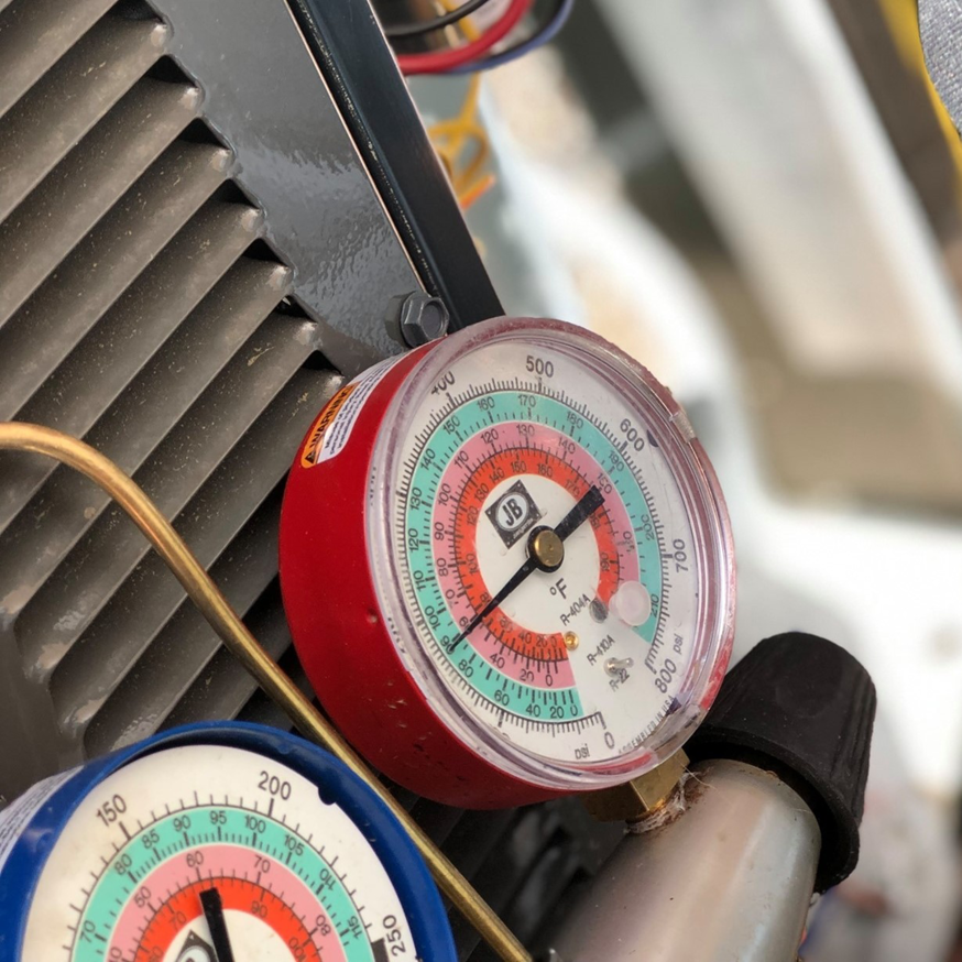 HVAC technician using refrigerant gauges to service an air conditioning unit by B3 Refrigeration LLC in Tempe, AZ