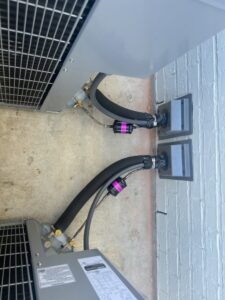 Close-up of HVAC refrigerant line connections and components on outdoor units by Alpha HVAC LLC in Alexandria, LA.