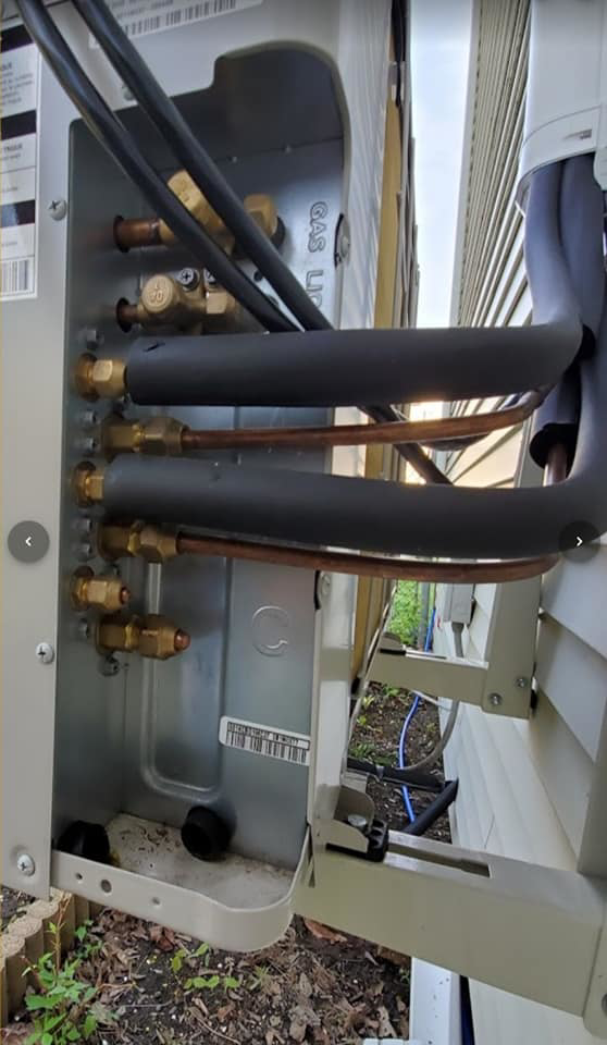 Detailed view of insulated HVAC refrigerant line connections on an outdoor unit by Global Sheetmetal Inc in Warwick, RI.