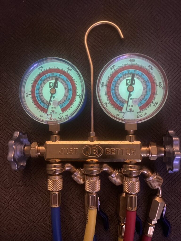 A set of HVAC refrigerant manifold gauges used by Subzero Mechanical LLC Heating & Air in Concord, NC.
