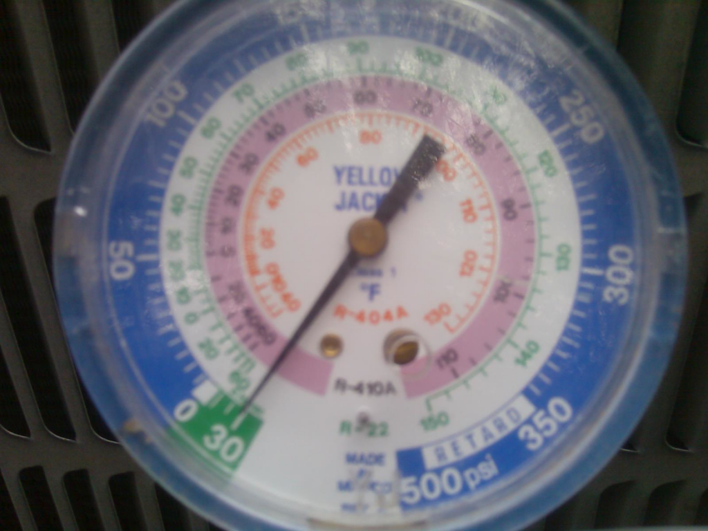 A refrigerant tank and gauges connected to an outdoor AC unit during service by J AND J HVAC L.L.C in Mesa, AZ