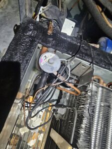 Close-up of internal components, including pipes and a pressure switch, within an HVAC or refrigeration unit by Henry Refrigeration & Hvac Utah in Ogden, UT.