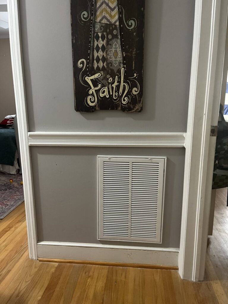 An HVAC return air vent installed on a gray wall inside a home by Krantz Kooling & Heating in West Columbia, SC