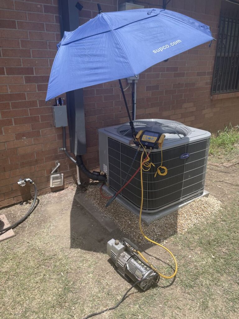 Outdoor AC unit undergoing service with a vacuum pump and gauges connected by Benavidez Heating & Air Conditioning In, Arlington, TX.