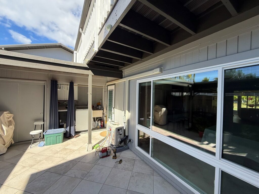 An HVAC technician performing service on an outdoor mini-split unit for Air Masters, Inc. in Port Orchard, WA.