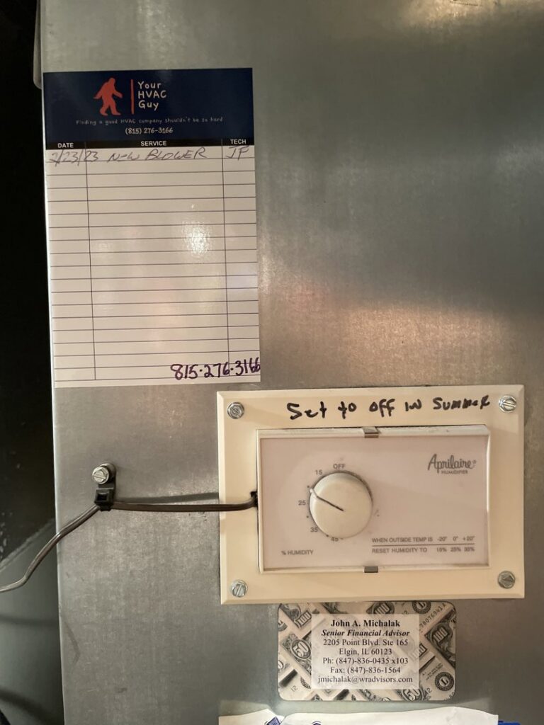 A service record sticker from Your HVAC Guy next to an Aprilaire humidifier control on ductwork in Aurora, IL.