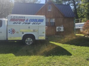 A T. D'Albora Heating and Cooling service truck parked next to a house with a newly installed mini-split unit in Erie, PA.