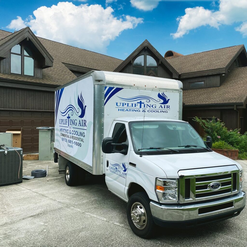 An Uplifting Air, LLC service truck parked at a residential job site with HVAC equipment in San Antonio, FL.