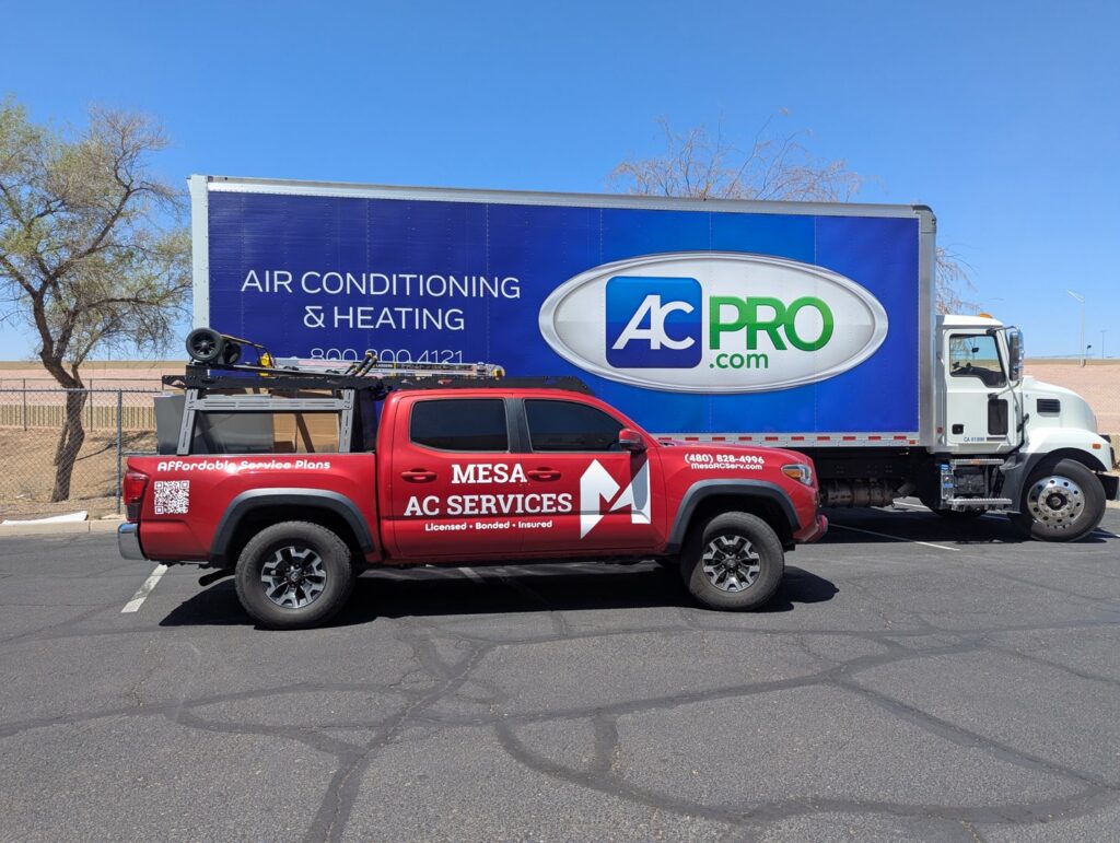 Two HVAC service trucks, one branded AC Pro and another Mesa AC Services, parked in Phoenix, AZ, ready for air conditioning and heating jobs.