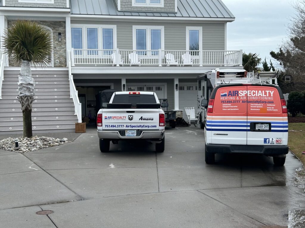 Air Specialty Heating & Air Conditioning service trucks parked outside a residential home in Norfolk, VA, ready for an HVAC job.