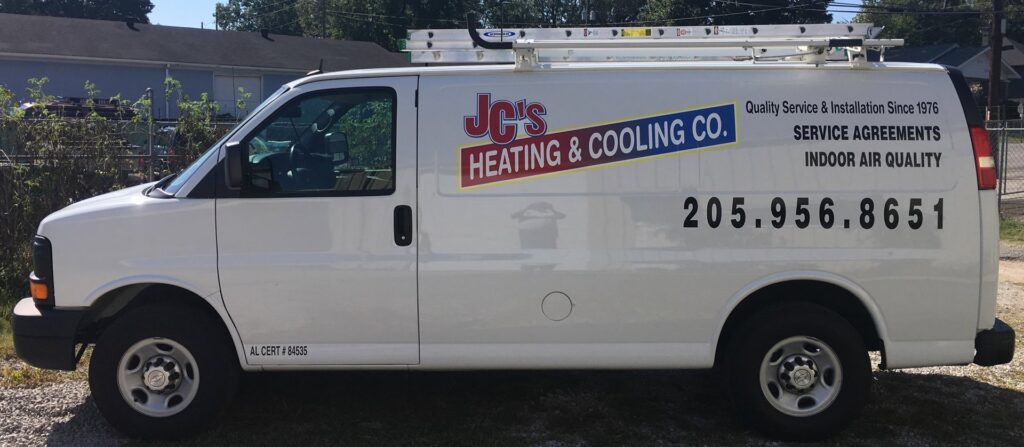 A white service van with JC's Heating and Cooling Co. branding and ladders, ready for HVAC jobs in Irondale, AL.