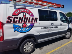 A Schuler Heating & Cooling HVAC service van with a ladder on the roof in Shorewood, IL.