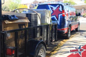A Larson Air Conditioning service van with a trailer carrying old HVAC equipment in Scottsdale, AZ