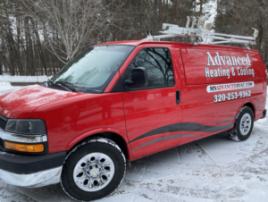 Advanced Heating & Cooling service van parked in a snowy winter landscape in St. Cloud, MN, ready for calls.
