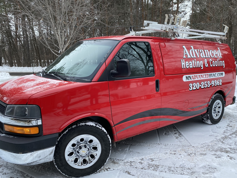 Advanced Heating & Cooling service van parked in a snowy winter landscape in St. Cloud, MN, ready for calls.