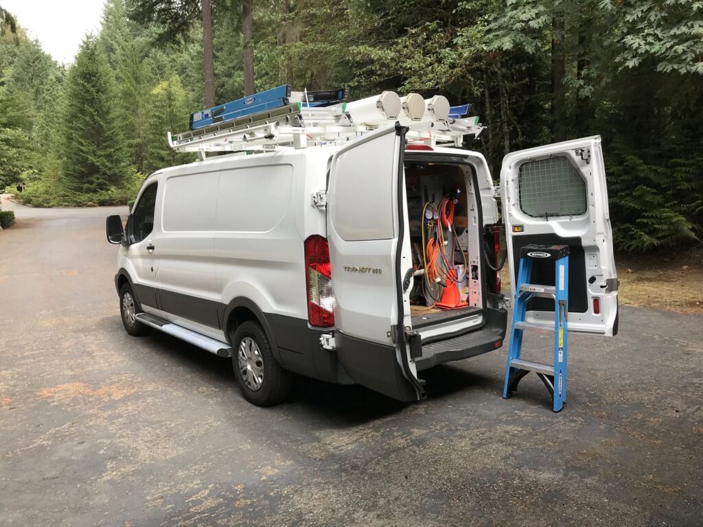 A Columbia Heating & Air Conditioning service van with its doors open, showing tools and equipment for HVAC jobs in Kent, WA.