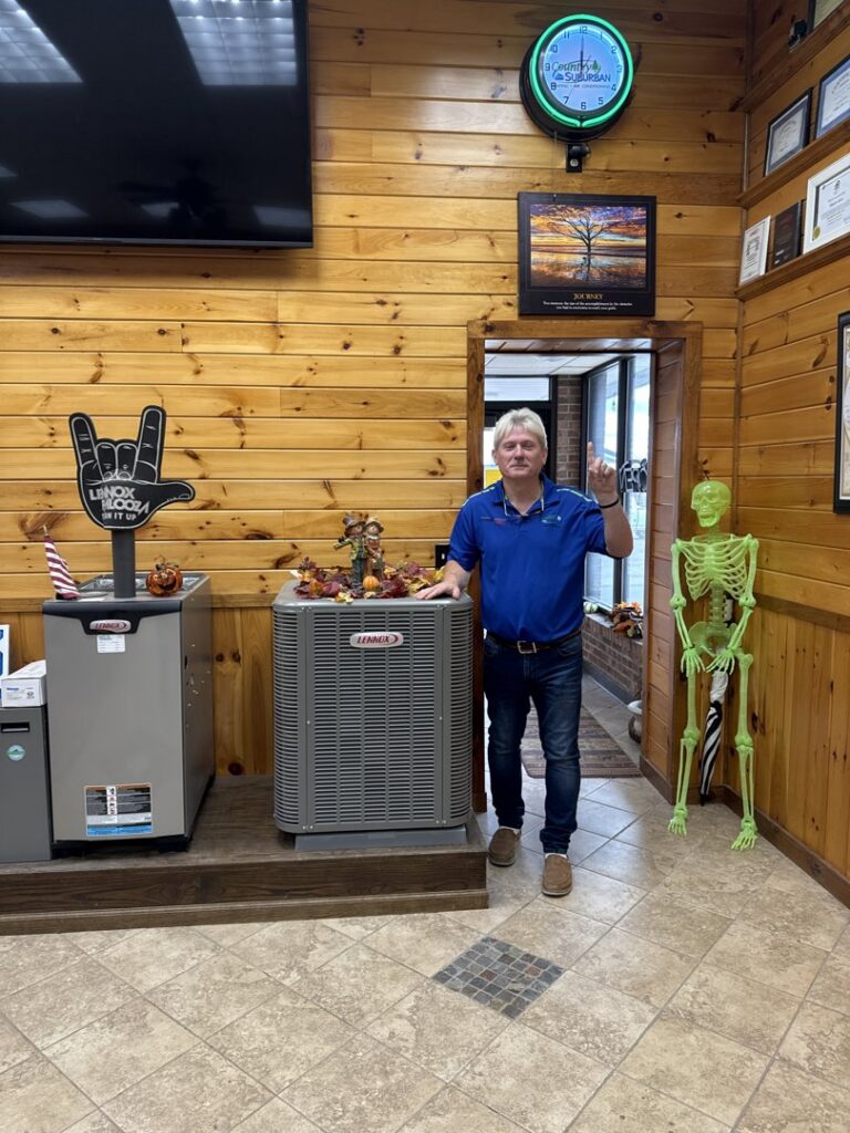 A man stands with Lennox HVAC units in the showroom of Country Suburban Heating & Air Conditioning & Sons, Inc. in Utica, NY.